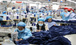 Workers process children's bedding products in a textile and clothing production workshop...