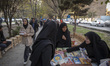 Iranian women look at the books while participating in the Book Street event commemorating...