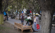 An Iranian woman adjusts her books on a traditional bed to sell them during a Book Street...