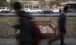 Iranian men walk past the books placed on a traditional bed on a pedestrian way during the...