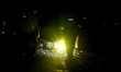 Law enforcement officers examine the body of a person killed in an airstrike carried out b...