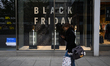 A person walks past a Black Friday advertisement displayed on a shop window in Warsaw, Pol...
