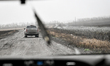 A car of the Armed Forces of Ukraine moves along a road lined with barbed wire used to det...