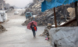 A Palestinian boy walks under the rain in Gaza City, on November 25, 2025. 