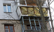 Apartment balconies in a residential high-rise are damaged by falling debris from a downed...