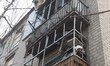 Damaged apartment balconies of a multi-storey residential building are hit by debris from...