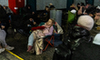 People try to sleep and rest while sheltering from shelling in an underground parking gara...