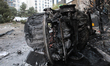 A burnt-out car lies on its side at a housing estate damaged by a Russian missile and dron...