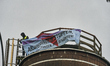 A protester attaches a banner to construction in Giessen, Germany, on November 28, 2025, d...
