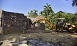 Workers of the Assam forest department demolish an illegal construction inside the Lutumar...