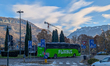 A bright green FlixBus intercity coach drives through a low-speed intersection with bicycl...