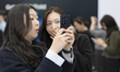 Journalists test the Galaxy Z TriFold, Samsung's new three-fold smartphone, during a media...