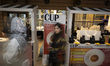 A young Iranian woman walks past coffee stands while visiting Iran's Coffee, Non-Alcoholic...