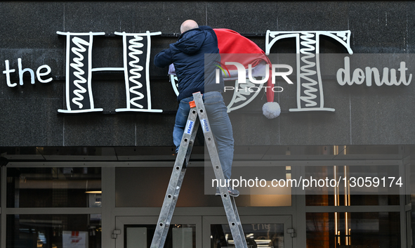 KATOWICE, POLAND – DECEMBER 4:
A man decorates a shop sign with Christmas ornaments in central Katowice, Silesian Voivodeship, Poland, on De... by Artur Widak/NurPhoto