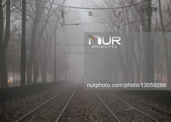 KRAKOW, POLAND - DECEMBER 4:
A pedestrian crosses tram tracks on Dietla Street amid dense afternoon fog in Krakow, Poland, on December 4, 20... by Artur Widak/NurPhoto