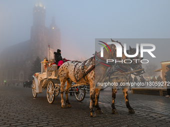 KRAKOW, POLAND – DECEMBER 4:
Horse carriages are seen stationed beside the Cloth Hall and Christmas Market in Krakow’s Main Market Square am... by Artur Widak/NurPhoto