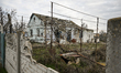 A house destroyed by Russian shelling on Partyzanska Street is behind a broken fence in Pa...