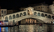 The Rialto Bridge, an iconic stone arch bridge spanning the Grand Canal, is illuminated at...