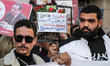 A demonstrator holds up a placard reading in Arabic ''men and women of my country are in t...