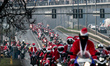 Hundreds of motorcycle drivers dressed as Santa Claus drive to the pediatric hospital to o...