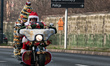 Hundreds of motorcycle drivers dressed as Santa Claus drive to the pediatric hospital to o...