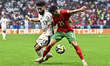 Karim El Berkaoui of Morocco and Nawaf Bu Washl of Saudi Arabia are in action during the G...