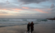 Palestinians spend their time on the Mediterranean coast during sunset in Gaza City, on De...