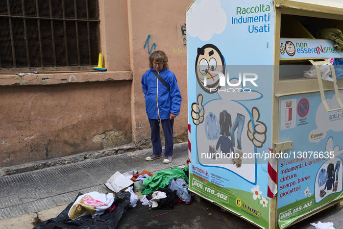 Woman Observes Pile Of Discarded Clothes Near Donation Container