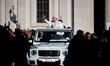 Pope Leo XIV waves to the crowd as he arrives aboard the popemobile during the weekly gene...