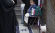 A young Iranian boy sits on an Israeli flag placed on the ground at the entrance of a spor...