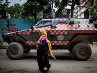 A passerby is walking on the street of Gulshan in front of the Police tank. July 2nd, 2016. Dhaka, Bangladesh. (