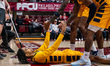 Jamari Piercy, 14, of the Coppin State Eagles is helped up during an NCAA men's basketball...