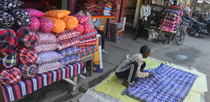 Editorial photo: A man sews a coating mattress at his shop in Siliguri, India, on December 13, 2025. These people earn some extra money during the winter season as well as the marriage season.  by Diptendu Dutta/NurPhoto