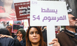A female protester holds up a sign reading in Arabic ''Down with decree 54'' during the an...