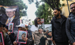 Ahmed Nejib Chebbi's daughter holds a placard featuring the portrait of her father during...