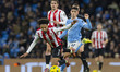 Kevin Schade, number 7 of Brentford F.C., is fouled by Phil Foden, number 47 of Manchester...