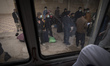 Afghan refugees wait to board a vehicle in the Milak refugee camp on Iran's eastern border...