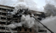 A firefighter uses an aerial ladder to suppress a fire in an apartment block hit by a Russ...