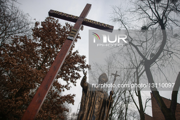 A cross and a statue of pope John Paul II is seen during the 44th anniversary of the pacification of the 'Wujek' coal mine in Katowice, Pola... by Beata Zawrzel/NurPhoto