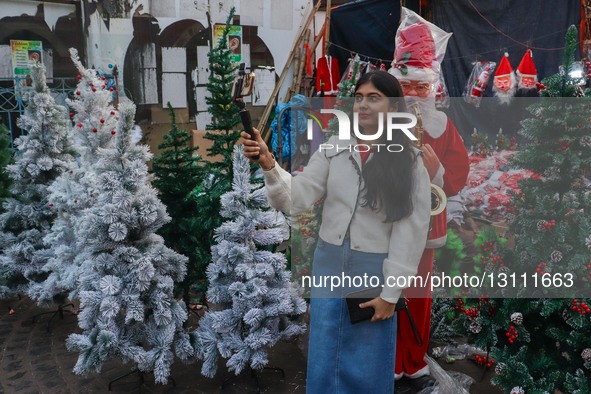 A lady takes a selfie with a figurine of Santa Claus at a market in Kolkata, India, on December 19, 2025, ahead of Christmas festivities in... by Debarchan Chatterjee/NurPhoto