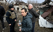 A rescuer stays by people affected by Russian shelling in Zaporizhzhia, Ukraine, on Decemb...