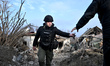 A police officer inspects a crater left by Russian shelling in Zaporizhzhia, Ukraine, on D...