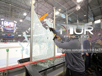 An arena staff member uses a shovel to take down the remaining section of a glass panel that shatters during a play in the first period of t... by Mike Campbell/NurPhoto