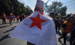 A participant holds a party flag during a unity message rally organized by the Nepali Comm...