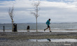 A person runs on the riverside in Lisbon, Portugal, on December 21, 2025. Rainy and cold w...