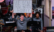 A member of the Saint Joseph's Hawks holds up a sign during an NCAA men's basketball game...
