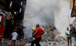 One of the shop owners walks past the remains of the burnt 25-storey Great Nigeria Insuran...