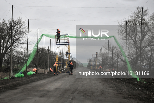 Workers install an anti-drone net over a road in the Dnipropetrovsk region, Ukraine, on December 24, 2025. The construction of protective tu...