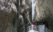 Hikers explore the Partnach Gorge (Partnachklamm), a natural monument carved by the mounta...