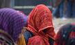 Women cover their faces while cooking inside a transit camp before heading to Sagar Island...